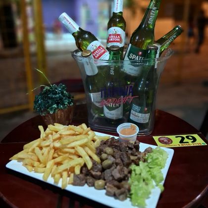 Balde com cervejas long neck e porção de carne com fritas