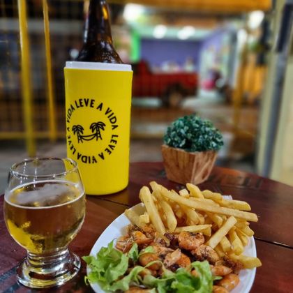 Cerveja gelada na mesa com petisco